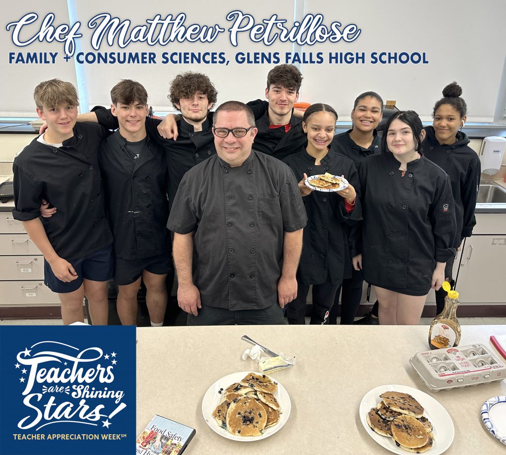 group of cullinary students stand with their teacher, with one holding a beautiful plate of blueberry pancakes that smells delicious