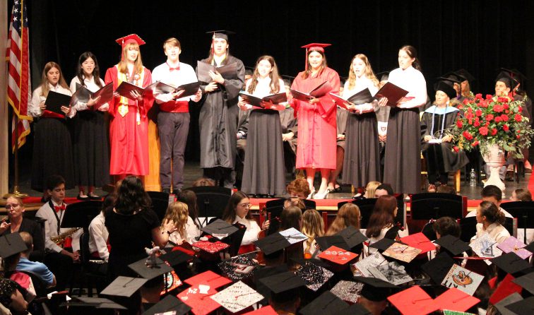 The Octet singers perform during the graduation ceremony, with three seniors wearing their caps and gowns