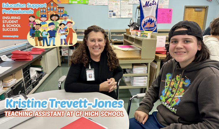 Teaching Assistant and student sitting together at a table in classroom smiling