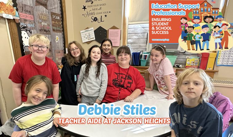 Teacher Aide surrounded by smiling kids in a classroom